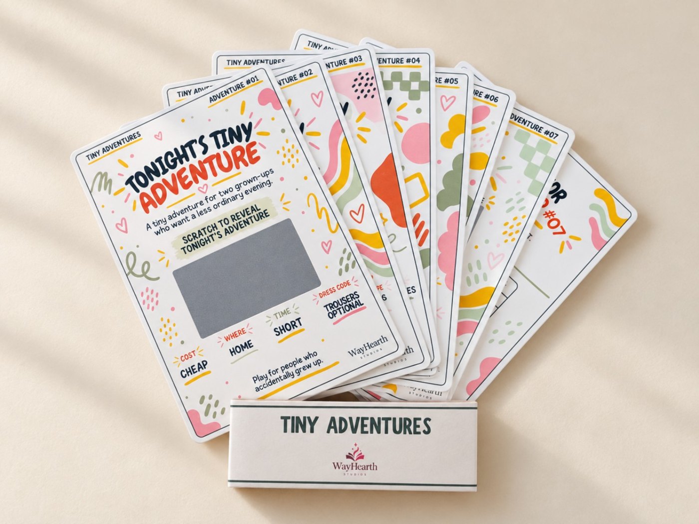 Tiny Adventures scratch-off card pack fanned out with seven adventure cards and belly band